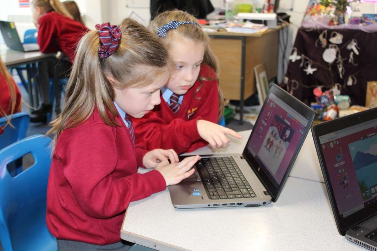 Children coding on laptops during after school club